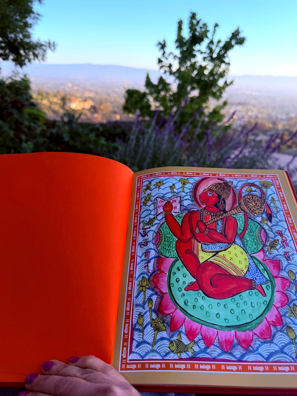 Interior spread — hand-painted Hanuman on a lotus, vibrant folk art in Phad style